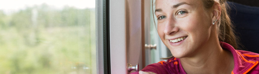 Leende kvinna åker tåg